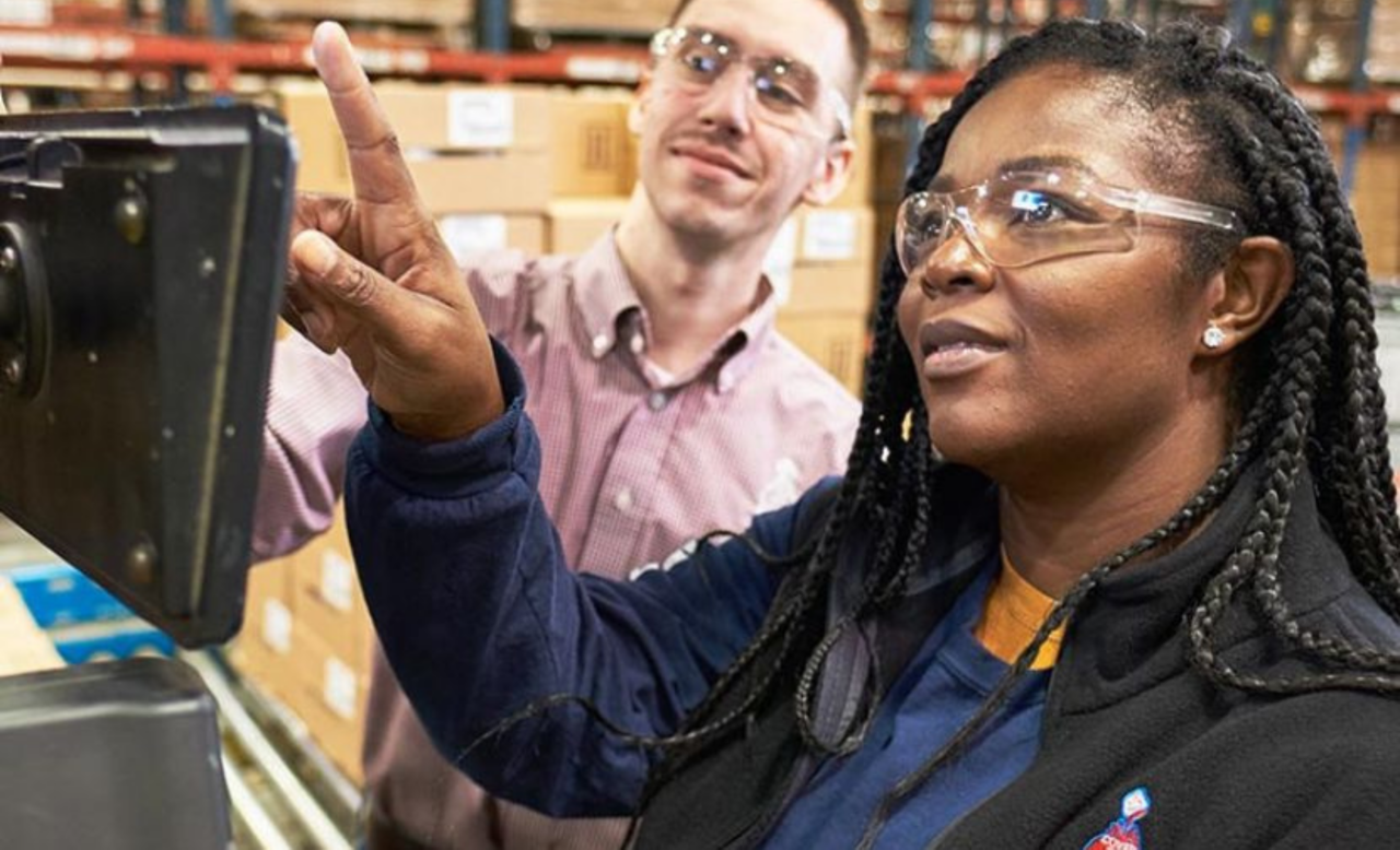 Two manufacturing employees example results on a screen together