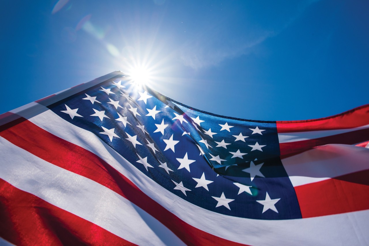 Close up United States of America flag on the blue sky background. USA Independence day, 4 July.